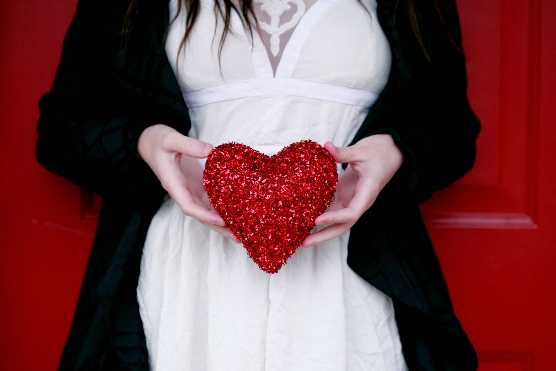 Woman in black & white dress holding a plush red heart
